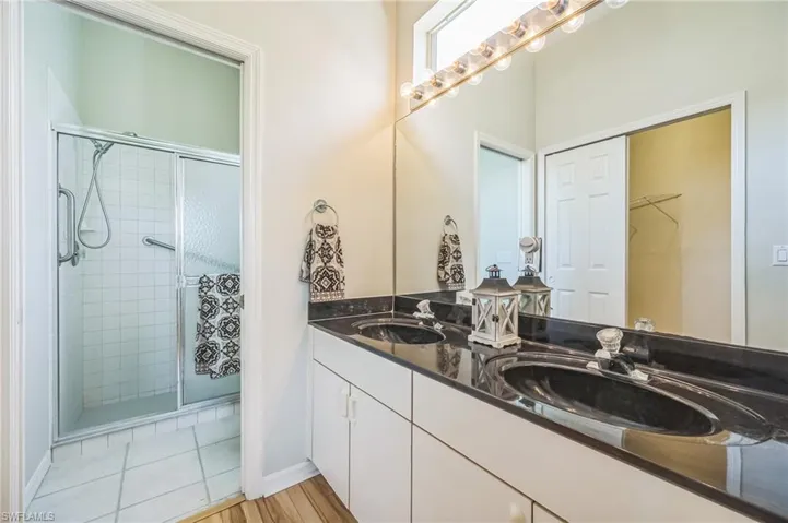 Bathroom with tile patterned flooring, vanity, and an enclosed shower