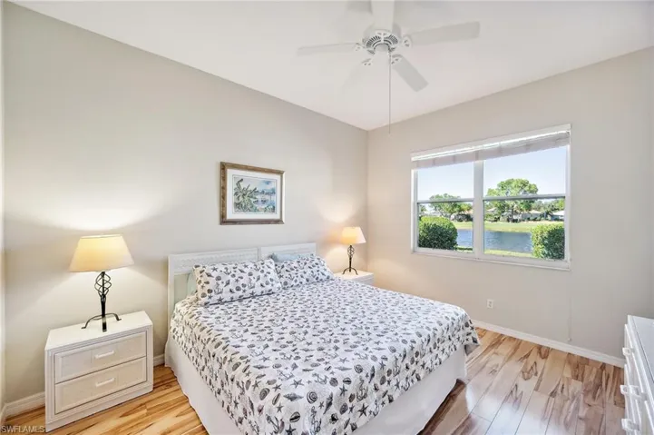 Bedroom with ceiling fan, a water view, and light wood-type flooring