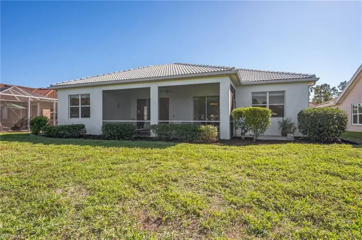 Back of property with a lawn