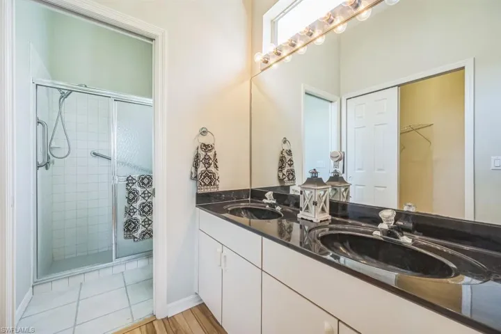Bathroom with tile patterned floors, vanity, and a shower with shower door