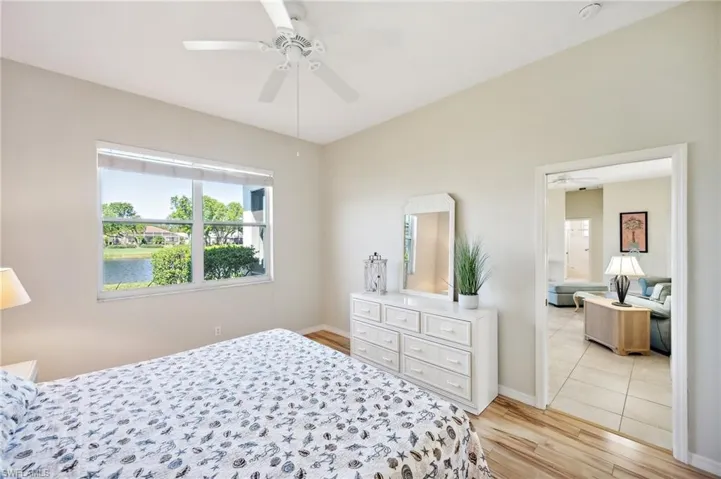 Bedroom featuring ceiling fan, light hardwood / wood-style flooring, and a water view