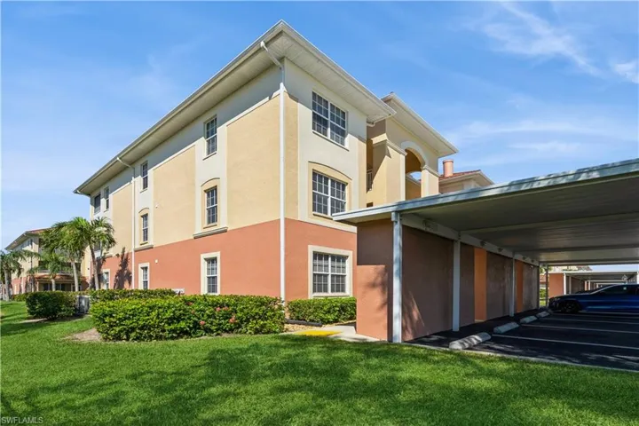 View of side of property featuring a lawn and a carport