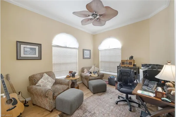 Office space featuring wood finished floors, ornamental molding, and ceiling fan
