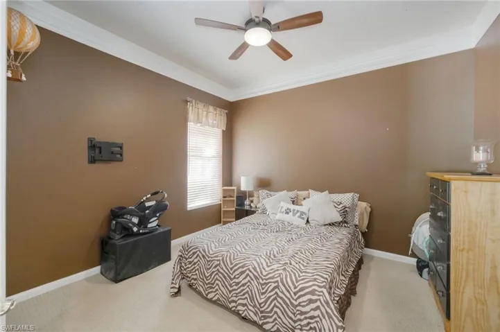 Bedroom with carpet flooring, crown molding, and ceiling fan