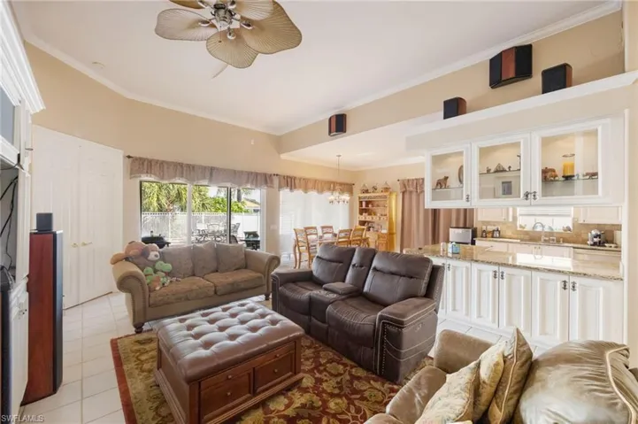 Living room with ornamental molding and light tile patterned floors