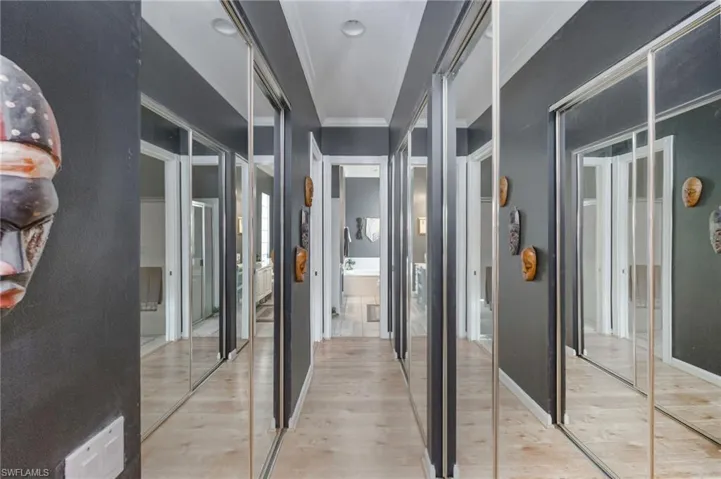 Corridor featuring wood finished floors and ornamental molding