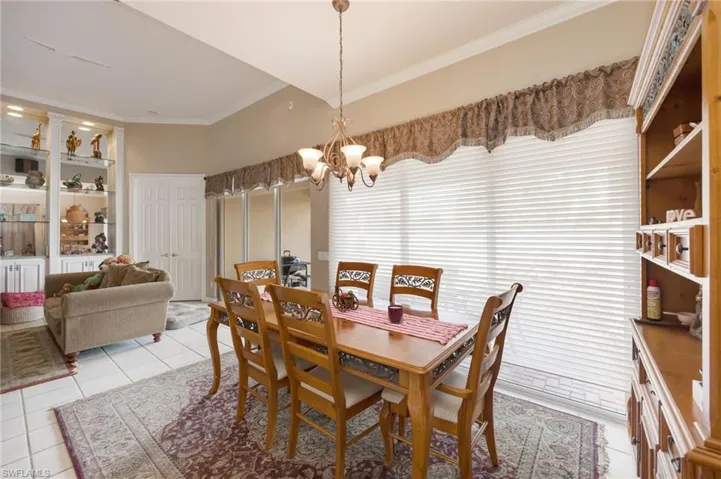 Dining room featuring ornamental molding, light tile patterned floors, and suspended lighting