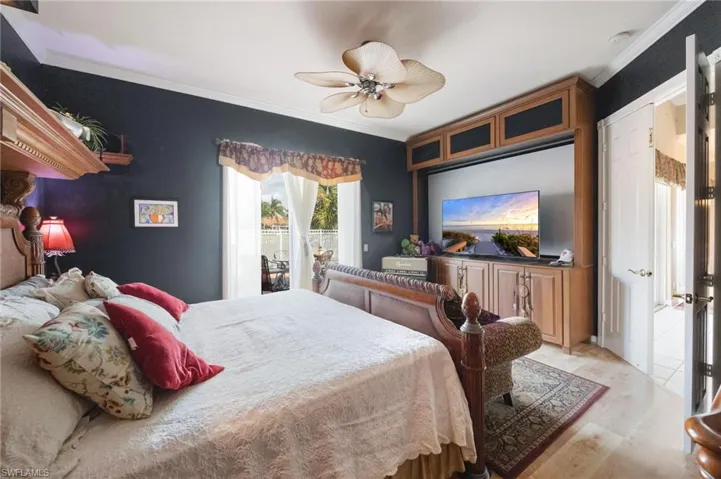 Bedroom with crown molding, light wood-type flooring, a ceiling fan, and access to outside