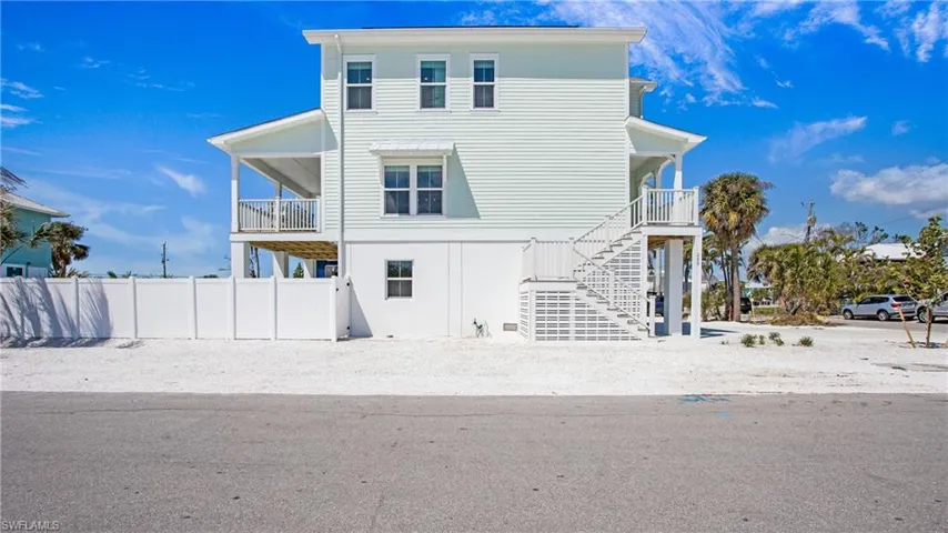 Back of property with stairs and a balcony
