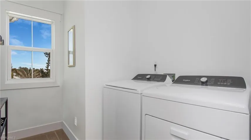 Washroom featuring independent washer and dryer and dark wood finished floors