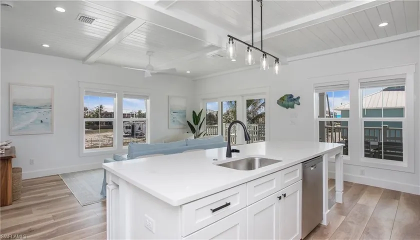 Kitchen featuring recessed lighting, a wood ceiling with exposed beams, open floor plan, light wood finished floors, and hanging light fixtures
