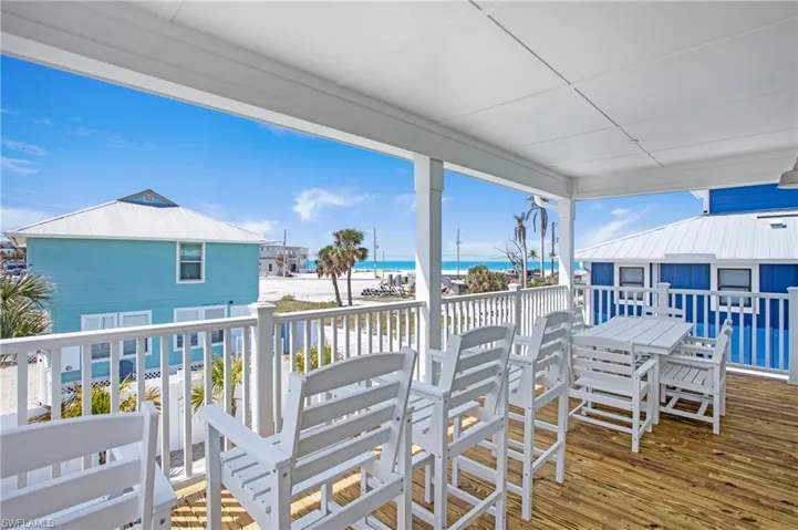 Wooden deck featuring view of water and beach