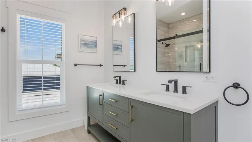 Full bath with a tile shower and double vanity