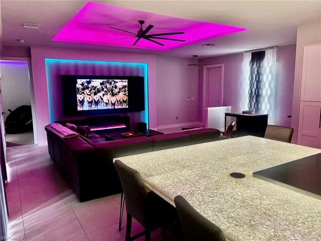 Cinema with light tile patterned floors and a ceiling fan