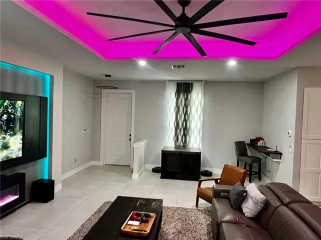 Living area with light tile patterned floors and a ceiling fan