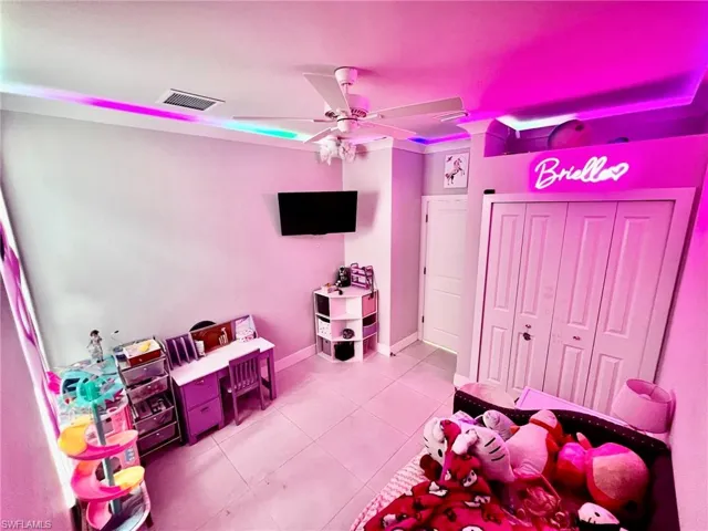 Recreation room with light tile patterned floors and ceiling fan