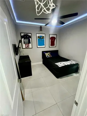 Bedroom featuring tile patterned floors and baseboards