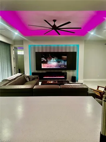 Home theater featuring a ceiling fan and baseboards