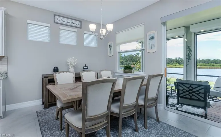 Dining area with a chandelier, light tile patterned floors, and a water view