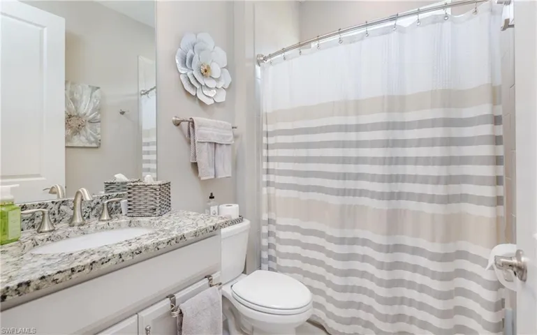 Full bathroom with vanity and curtained shower