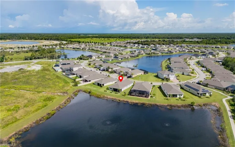 Aerial view of property and surrounding area featuring a nearby body of water and nearby suburban area