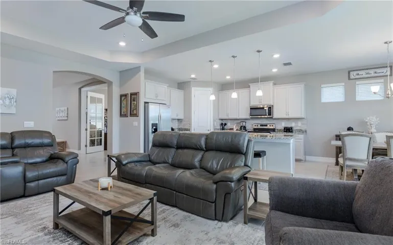 Living area featuring arched walkways, recessed lighting, and a ceiling fan