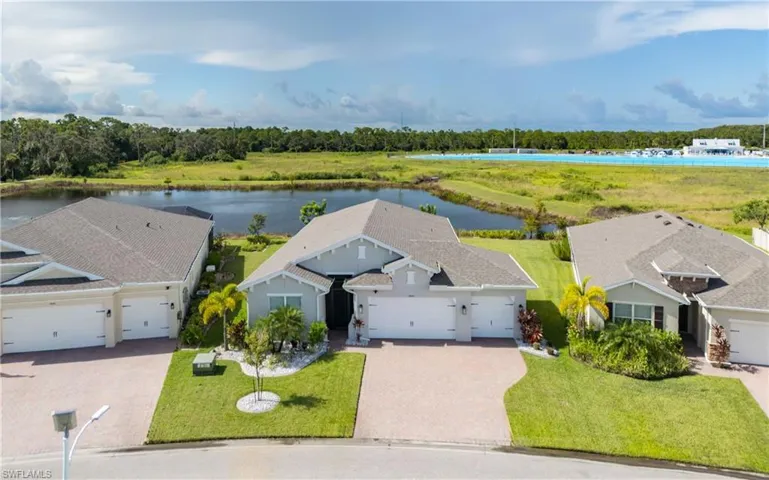 View of subject property with a nearby body of water and a tree filled landscape