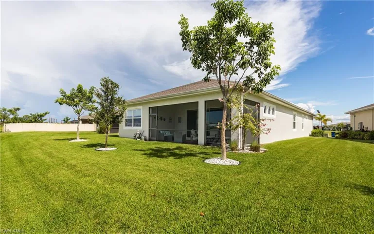 Back of property with a yard, stucco siding, and a sunroom