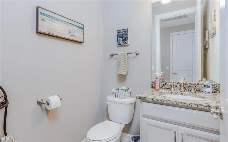 Half bath featuring toilet and vanity