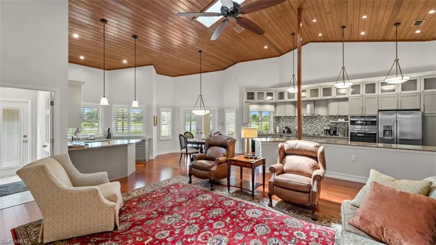 Spacious living area featuring a vaulted wood-finish ceiling with a skylight, recessed lighting, and a ceiling fan