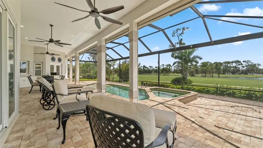 Screened lanai featuring a swimming pool and attached spa, paver patio, and multiple ceiling fans