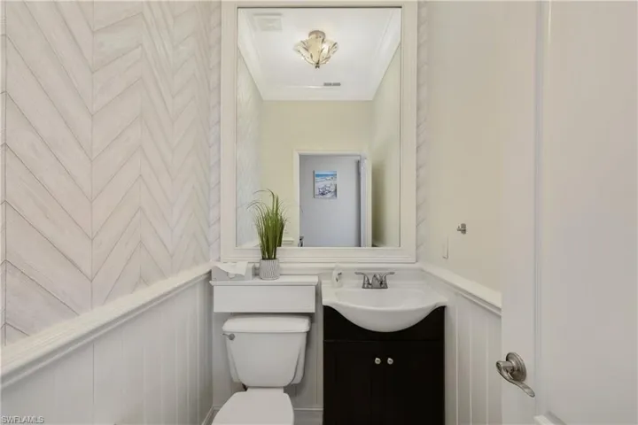 Bathroom with crown molding, oversized vanity, and toilet