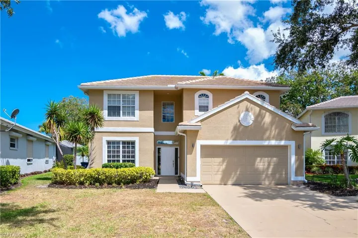 View of front facade with a garage and a front lawn
