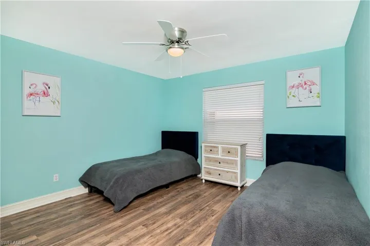Bedroom with dark wood-type flooring and ceiling fan
