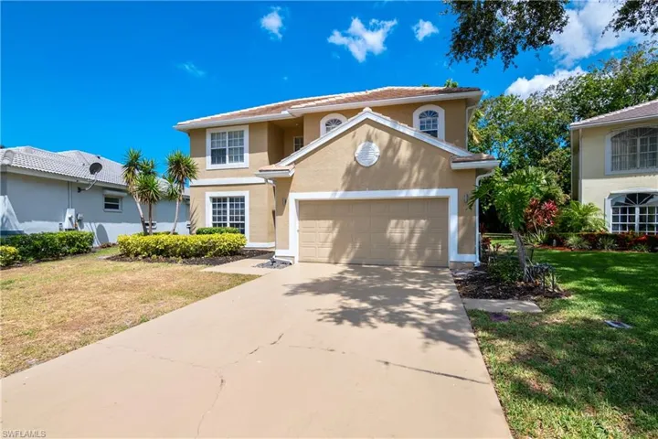 View of front facade with a garage and a front lawn