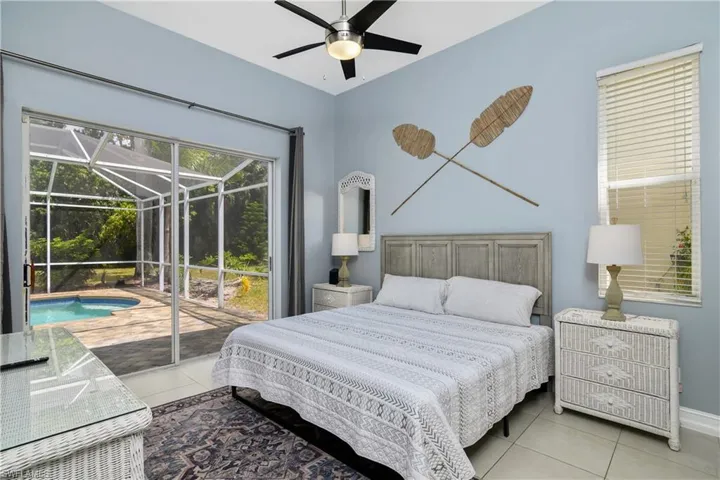Tiled bedroom featuring ceiling fan and access to exterior