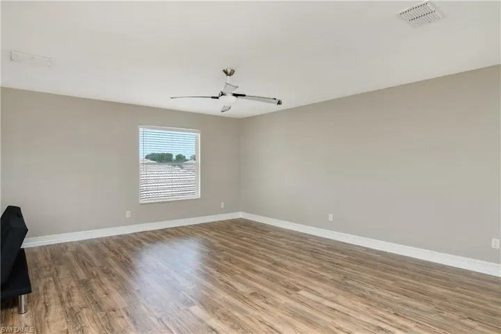 Empty room featuring dark hardwood / wood-style floors and ceiling fan
