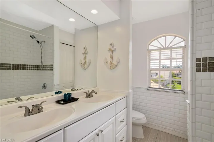 Bathroom featuring dual vanity and toilet