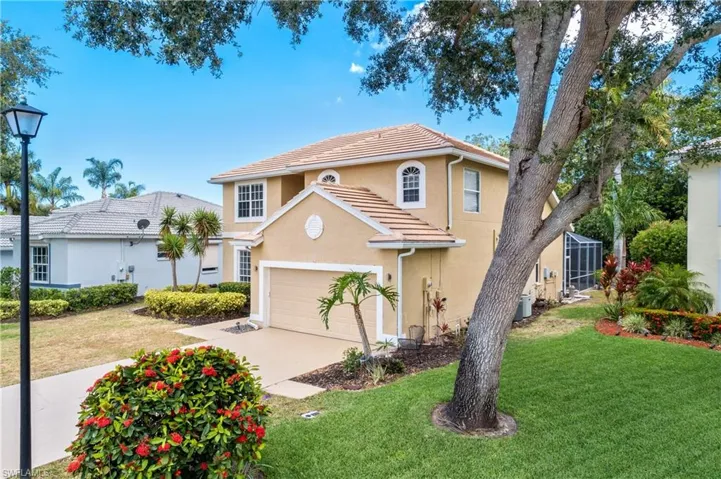View of front of property with a garage and a front lawn