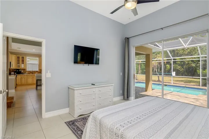 Bedroom featuring ceiling fan, light tile flooring, and access to exterior