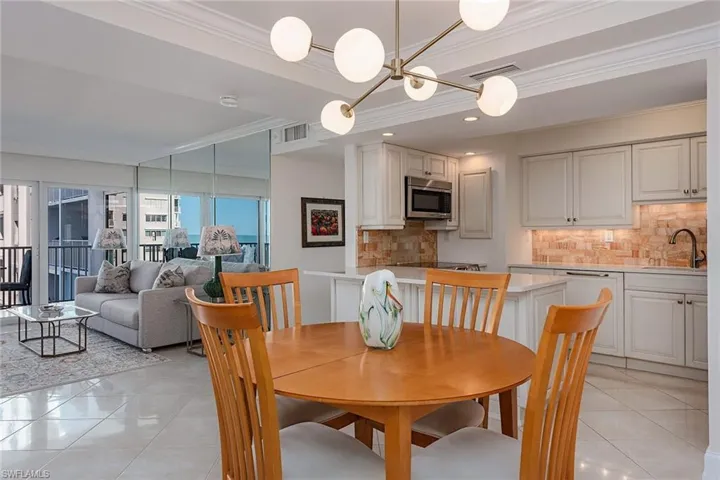 Dining area with ornamental molding and light tile patterned flooring