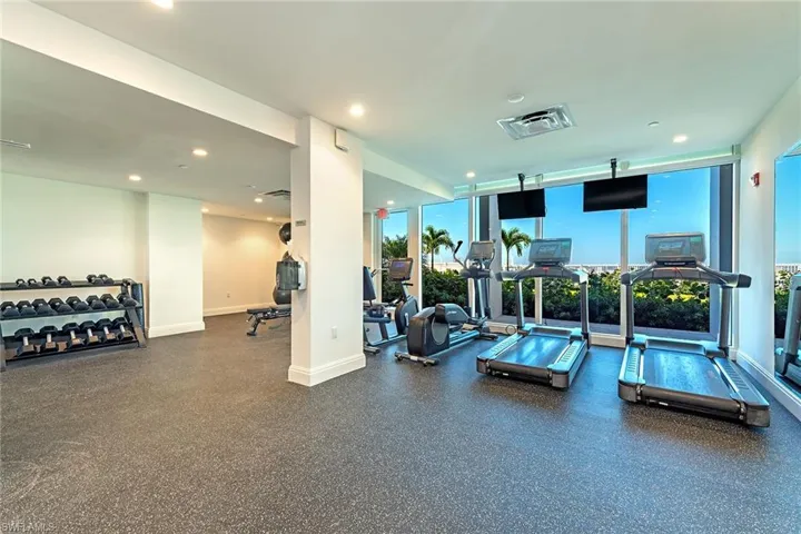 Exercise room with floor to ceiling windows and recessed lighting