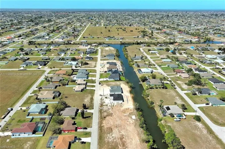 Aerial view of property's location with nearby suburban area and a nearby body of water