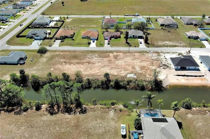 Aerial view of property and surrounding area with a large body of water and nearby suburban area