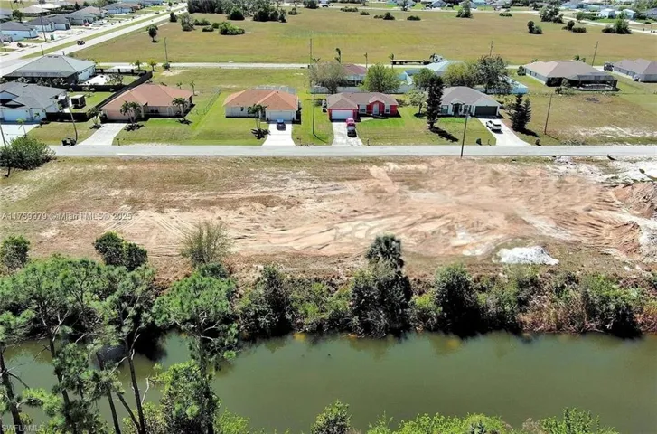 Aerial perspective of suburban area featuring a nearby body of water