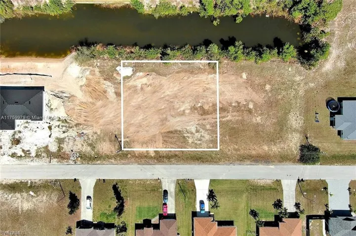 Aerial view of property and surrounding area with property boundaries highlighted and a nearby body of water