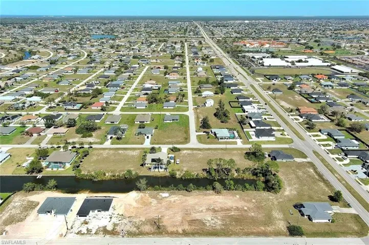 Aerial overview of property's location with nearby suburban area and a nearby body of water