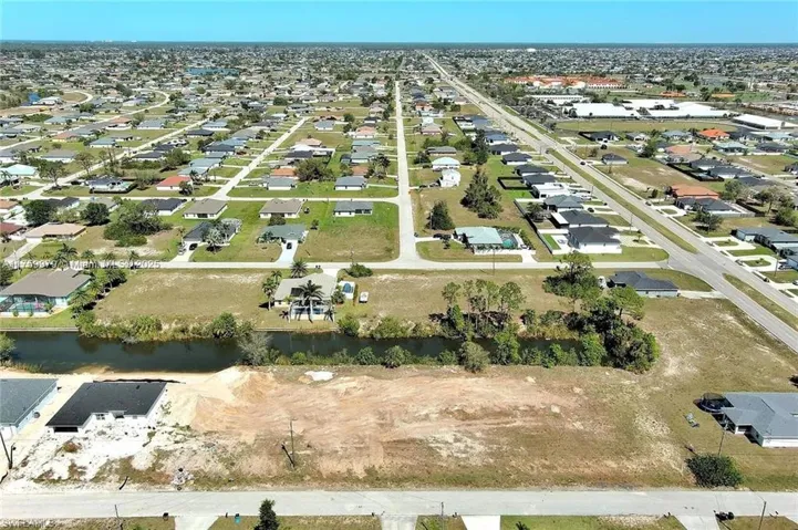 Aerial view of property's location featuring a large body of water and nearby suburban area