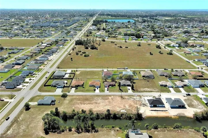 Aerial view of property's location with a nearby body of water and nearby suburban area