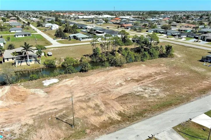 Aerial view of property's location featuring a nearby body of water and nearby suburban area